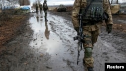 FILE - A Ukrainian serviceman in December passes a checkpoint near the eastern Ukrainian town of Debaltseve, Dec. 24, 2014.