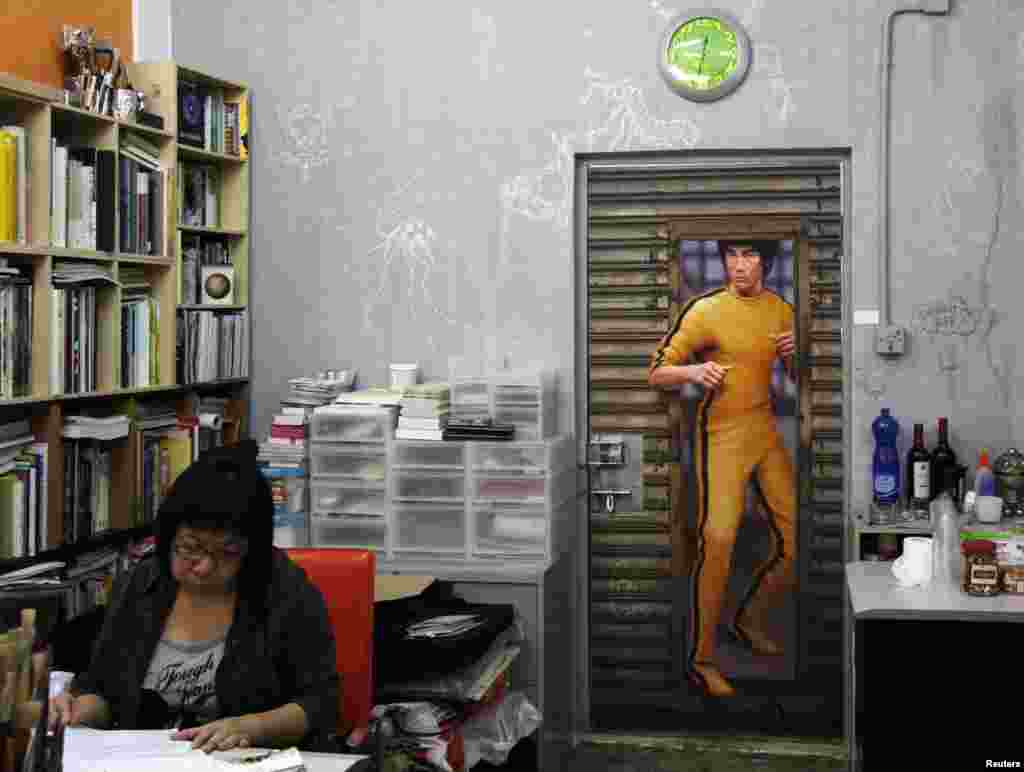 A woman works inside a Hong Kong gallery exhibiting paintings of the late kung fu legend Bruce Lee by local artists. Fans are marking his death 40 years ago this weekend with art gallery shows, exhibitions and even street graffiti, though some people are urging Hong Kong's government to do more to honor the former British colony's biggest star.