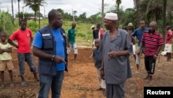 Kande-Bure Kamara from WHO speaks with community leaders at the construction site of a Ebola Care Unit in Kamasondo Village, Port Loko District, Oct. 8, 2014.