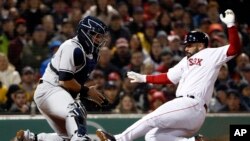 Boston Red Sox's Sandy Leon scores as New York Yankees catcher Gary Sanchez doesn't handle the throw during the second inning of a baseball game at Fenway Park in Boston on April 12, 2018. 