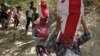 Residents affected by earthquake and tsunami carry aid provided during the visit of Indonesian President Joko Widodo in Donggala, north of Palu, Central Sulawesi, Indonesia, Oct. 3, 2018 in this photo taken by Antara Foto. 