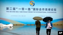 人们走过在北京召开的第二届一带一路国际合作高峰论坛宣传板。（2019年4月27日）