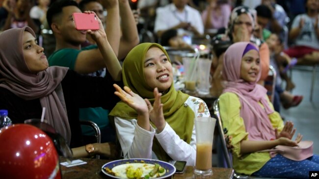 Warga Malaysia di sebuah restoran bersorak-sorai menonton televisi saat Mahathir Mohamad dilantik sebagai PM Malaysia ke-7 di Kuala Lumpur, Kamis (10/5).