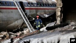 This photo provided by Mizan News Agency, shows an Iranian rescue works at the site of a Boeing 707 cargo plane crash, at Fath Airport about 40 kilometers (25 miles) west of Tehran, Iran, Jan. 14, 2019.