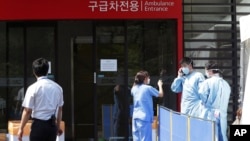 FILE - Hospital workers wear masks as a precaution against the Middle East Respiratory Syndrome (MERS) virus as they work in front of an emergency room of Samsung Medical Center in Seoul, South Korea, June 7, 2015. 