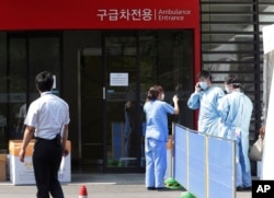 FILE - Hospital workers wear masks as a precaution against the Middle East Respiratory Syndrome (MERS) virus as they work in front of an emergency room of Samsung Medical Center in Seoul, South Korea, June 7, 2015.