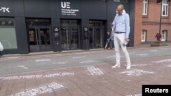 A man takes pictures of "hate tweets", a part of the art project "#HEYTWITTER" created by Shahak Shapira, outside Twitter office in Hamburg, Germany, Aug. 4, 2017, in this picture obtained from social media. 