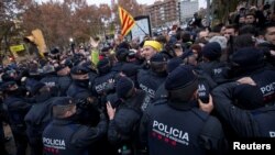 Catalan regional police officers scuffle with protesters in front of the Museum of Leida after police entered the museum to carry out an order and return over 40 contested artworks to the Spanish region of Aragon following a protracted legal battle in Lleida, Spain, Dec. 11, 2017. 