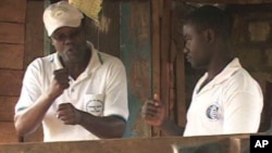FILE: Joseph Shiroko, founder of Brian Resource Center, communicates with a student in sign language