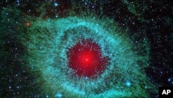 This infrared image from NASA's Spitzer Space Telescope shows the Helix nebula, with a white dwarf visible as a tiny white dot in the center of the picture.