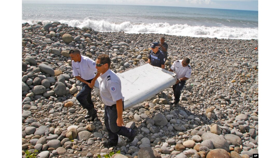 French police officers carry a piece of debris from a plane in Saint-Andre, Reunion Island, July 29, 2015.