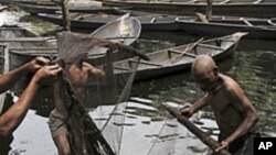 Fishermen sort out their fishing net at the bank of a polluted river in Bidere community in Ogoniland in Nigeria's delta region.