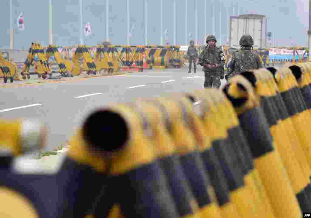 South Korean soldiers walk by barricades on the road leading to North Korea's Kaesong joint industrial complex at a military checkpoint in the border city of Paju. Military tensions between the North and South soared following a rare exchange of artillery shells across their heavily fortified border on Thursday.