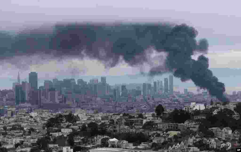 Smoke rises over the San Francisco skyline as a fire burns in the Mission District.