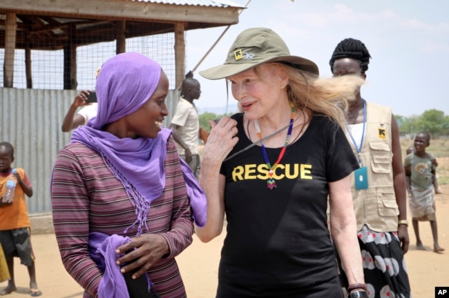 FILE - Human rights activist Mia Farrow talks with staff from the International Rescue Committee while visiting an internally displaced persons camp in Juba, South Sudan. As envoy for the International Rescue Committee, she is helping the aid group promote a global initiative to change the way humanitarian organizations approach malnutrition.