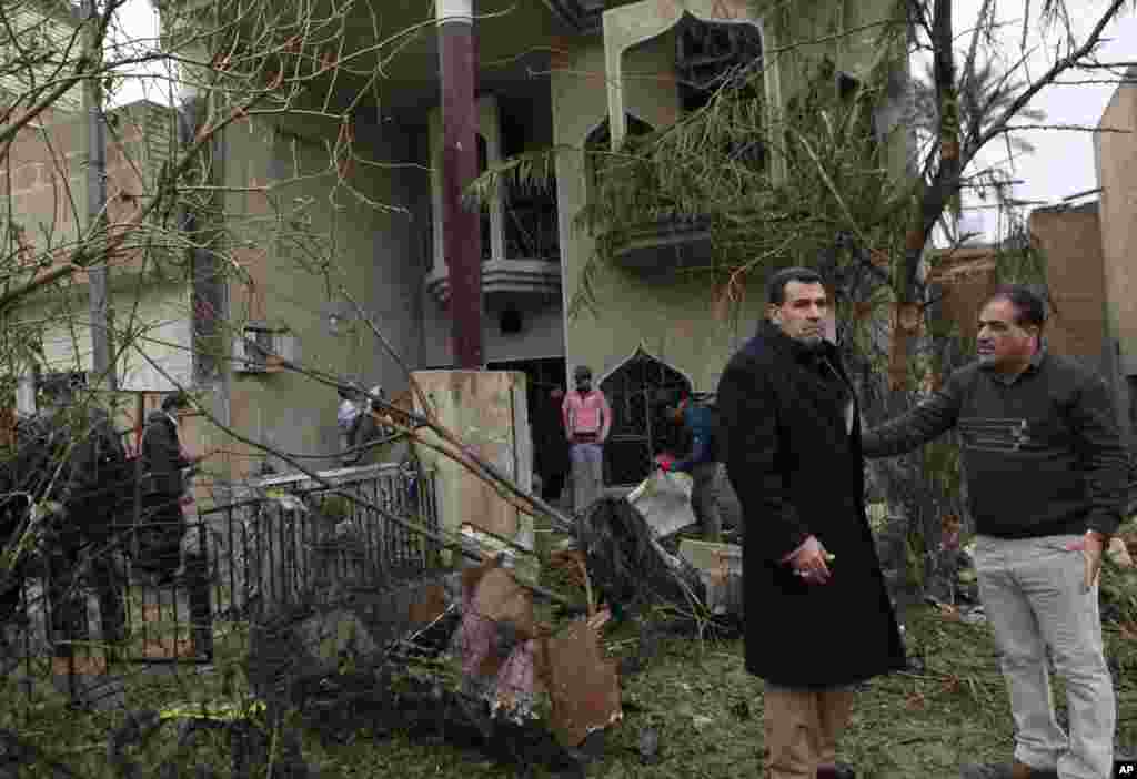 Civilians inspect their damaged house after a car bombing in the Hurriyah neighborhood of northern Baghdad, Feb. 3, 2014. 