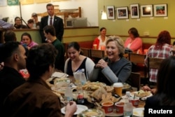 U.S. Democratic presidential nominee Hillary Clinton sits down for lunch with winners of an HFA contest at The Works Bakery Cafe in Durham, New Hampshire, Sept. 28, 2016.