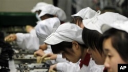 资料照 - 深圳的富士康代工厂里的工人们正在紧张工作。