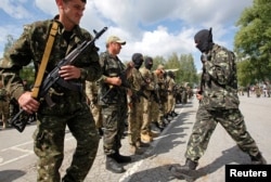 FILE - Members of the Donbass self-defense battalion attend a ceremony to swear an oath to be included in a reserve battalion of the National Guard of Ukraine near Kyiv, June 23, 2014.