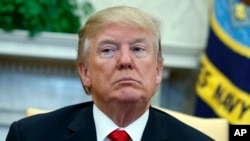 FILE - President Donald Trump listens during a meeting in the Oval Office of the White House, Feb. 2, 2018.