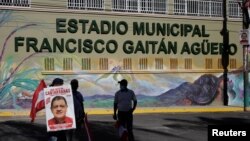 Un hombre sostiene un cartel durante el velorio de Francisco Gaitán, alcalde del municipio de Cantarranas y miembro del Partido Liberal, quien fue asesinado luego de un mitin político previo a las elecciones generales, en Cantarranas, Honduras, el 14 de noviembre de 2021.