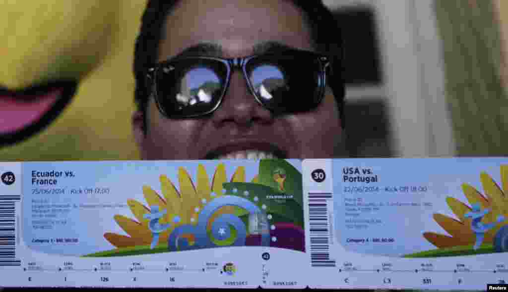 Brazilian soccer fan Anderson poses in front of the media after picking up his 2014 World Cup tickets in Rio de Janeiro. FIFA venue ticketing centers were opened in the World Cup host cities.