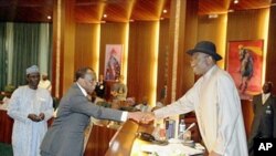 Rais mpya wa Nigeria (kulia) Goodluck Jonathan akimpongeza waziri wake mpya wa Fedha Olusegun Aganga