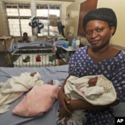 Mabel Ighedosa, 30, sits with her newborn triplets Isaac, Treasure and Samuel in a ward of the Lagos Island Maternity Hospital in Lagos, Nigeria, October 31, 2011.