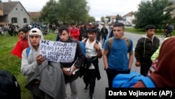 Hundreds of migrants stuck in Serbia set off on foot toward the border with Hungary to protest its closure for most people trying to reach the European Union.