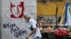 Un hombre pasa junto a un grafiti que exige la libertad del empresario colombiano Alex Saab, en Caracas, el 23 de febrero de 2021. 
