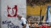 Un hombre pasa junto a un grafiti que exige la libertad del empresario colombiano Alex Saab, en Caracas, el 23 de febrero de 2021. 
