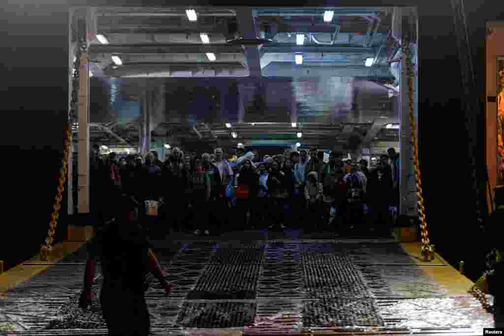 Refugees and migrants arrive on a passenger boat from the island of Lesbos at the port of Piraeus, Greece.