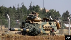 FILE - A Turkish army tank appears near the Syrian border in Suruc, Turkey, Sept. 3, 2016. Since then, tanks have entered Syria's Cobanbey district, northeast of Aleppo, as part of the Euphrates Shield operation to support Syrian rebels against IS.