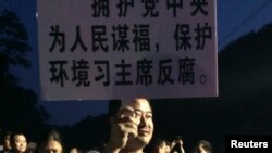 A demonstrator holds a placard during a protest against the construction of a waste incinerator in Hangzhou, Zhejiang province May 7, 2014. 