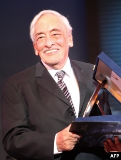 Egyptian actor Gamil Ratib holds his honorary award during the opening ceremony of the Alexandria Film Festival for Mediterranean Countries in the Egyptian port city of Alexandria, late on September 14, 2010.