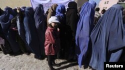 Afghan women line up to receive winter relief assistance donated by the United Nations High Commissioner for Refugees (UNHCR) in Kabul, January 2, 2013. 