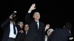 Turkish Prime Minister Recep Tayyip Erdogan , center, and his wife Emine wave to the crowd upon their arrival at the Ataturk Airport of Istanbul early June 7, 2013.