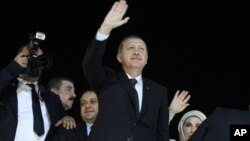 Turkish Prime Minister Recep Tayyip Erdogan (C) and his wife Emine wave to the crowd upon their arrival at the Ataturk Airport of Istanbul early June 7, 2013.