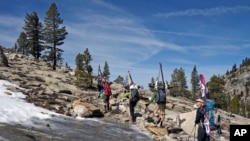 Mary Small, right, looks up at the bony and barren terrain typically skied in Sequoia National Park as she and other backcountry skiers hike back to civilization from the Pear Lake cabin, April 1, 2015.