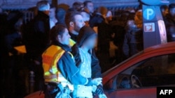 Picture taken on Jan. 1, 2016 shows police arresting a man as people gather in front of the main railway station in Cologne, western Germany.