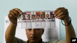 En la foto de archivo un funcionario electoral muestra una boleta marcada para el candidato presidencial del Partido Libre, Xiomara Castro, durante el conteo manual de votos después del cierre de las urnas en Tegucigalpa, Honduras, el domingo 24 de noviembre de 2013. 