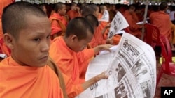 Cambodian monks reading a popular newspaper called 'Khmer Mchas Srok'. 