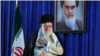 Iranian Supreme Leader Ayatollah Ali Khamenei gestures to a crowd at a June 4, 2019 ceremony in Tehran marking the 30th anniversary of the death of his predecessor, Ayatollah Ruhollah Khomeini, whose portrait appears behind him.