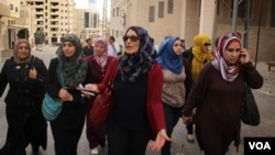 Maysoun Qawasmi (tengah) dan pendukungnya berjalan di kota di Tepi Barat menuju tempat pemungutan suara. (VOA/R. Collard)