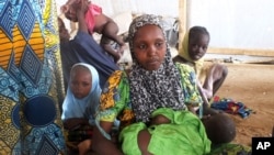 FILE - A family of refugees that fled their homes due to violence from the Islamic extremist group Boko Haram sit inside a refugee camp in Minawao, Cameroon, Feb. 25, 2015.