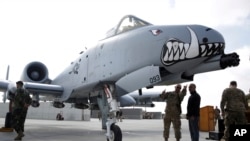 FILE - U.S. military forces stand beside an A-10C Thunderbolt II ground attack aircraft at Kandahar Airfield, Afghanistan, Jan. 23, 2018.