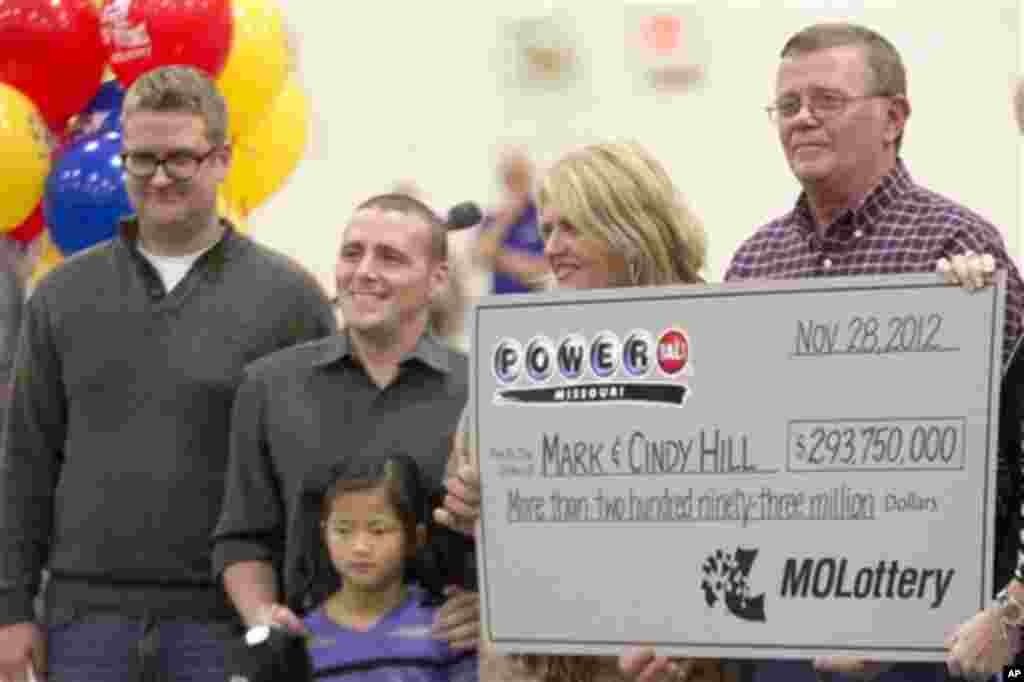 Mark and Cindy Hill hold a Powerball check with their three of their four children, Jarod, left, Cody and six-year-old Jaiden in Dearborn, Mo., Friday, Nov. 30, 2012. (AP Photo/Orlin Wagner)