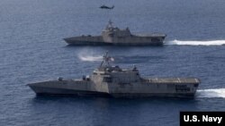 美军“蒙哥马利”号（USS Montgomery）（上）和“吉福兹”号（USS Gabrielle Giffords）濒海战斗舰2020年1月20日在一家海鹰直升机的掩护下在南中国海执行任务。