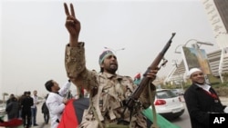 An armed Libyan rebel chants anti-Gadhafi slogans during a rally iin Benghazi, March 13, 2011