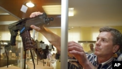 Un empleado de Rosobornexport, la exportadora estatal de armas rusa, arregla un rifle de asalto en exhibición en Moscú. La compañía rusa ha sido sancionada por EE.UU.